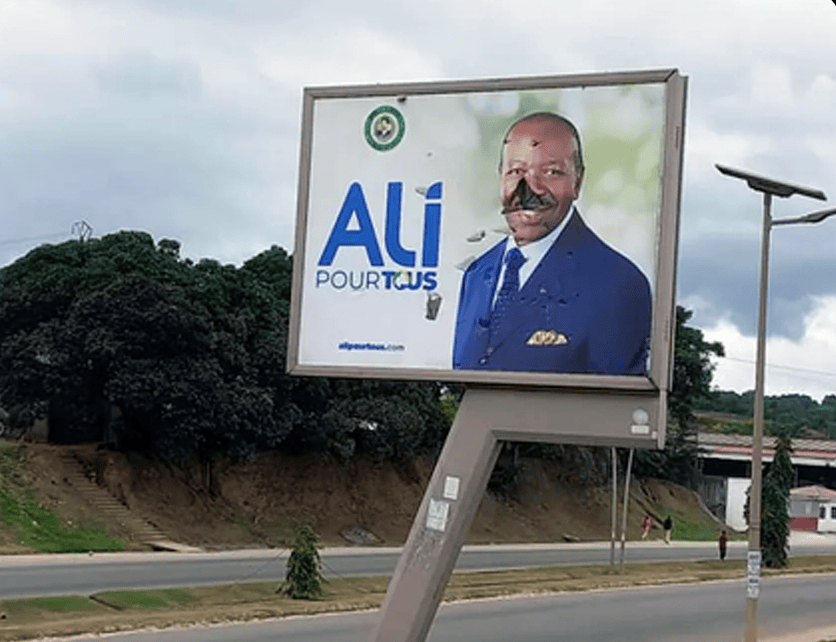A vandalized billboard of former Gabonese president Ali Bongo is seen in Libreville (AP Photo)